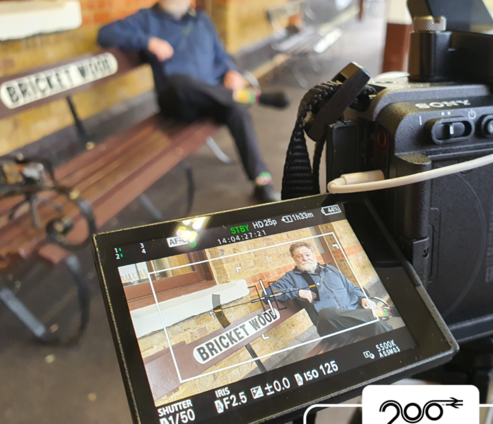 A man being interviewed on video at a train station