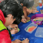 Children decorating paper leaves to write pledges to help the environment on