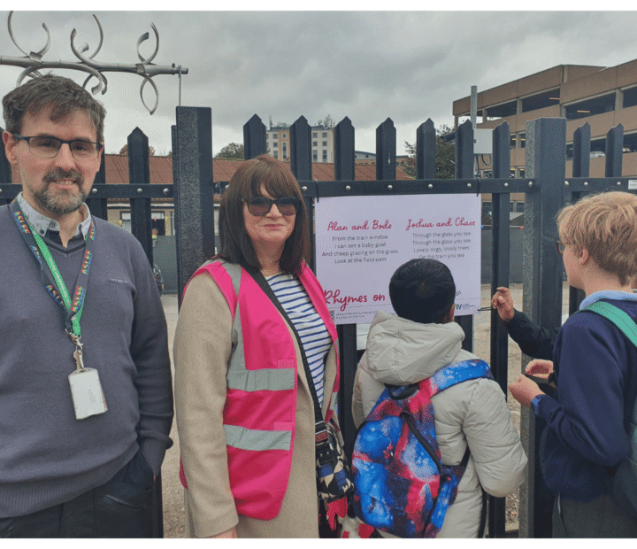 School children looking at creative work on a train platform