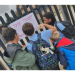 School children looking at creative work on a train platform
