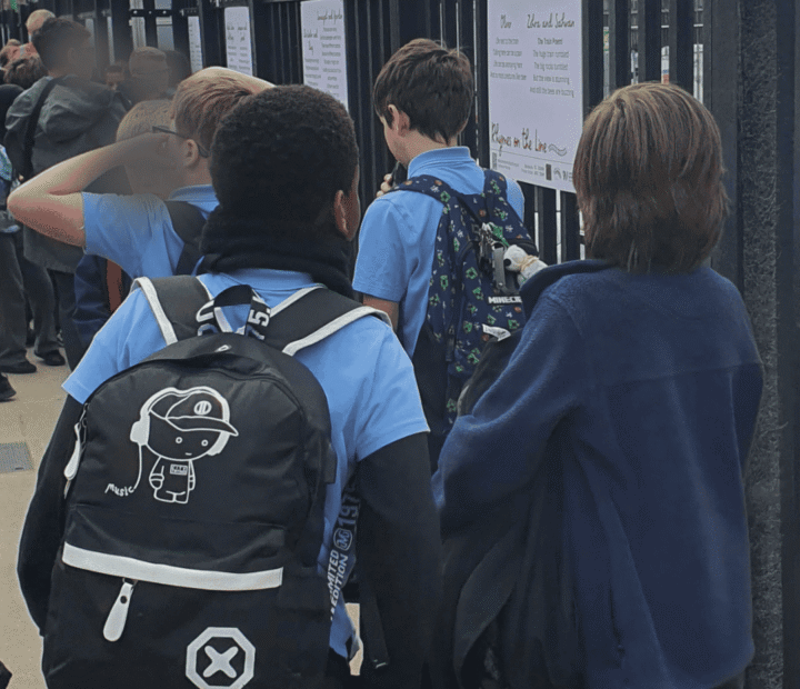 School children looking at creative work on a train platform