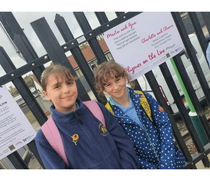 School children looking at creative work on a train platform