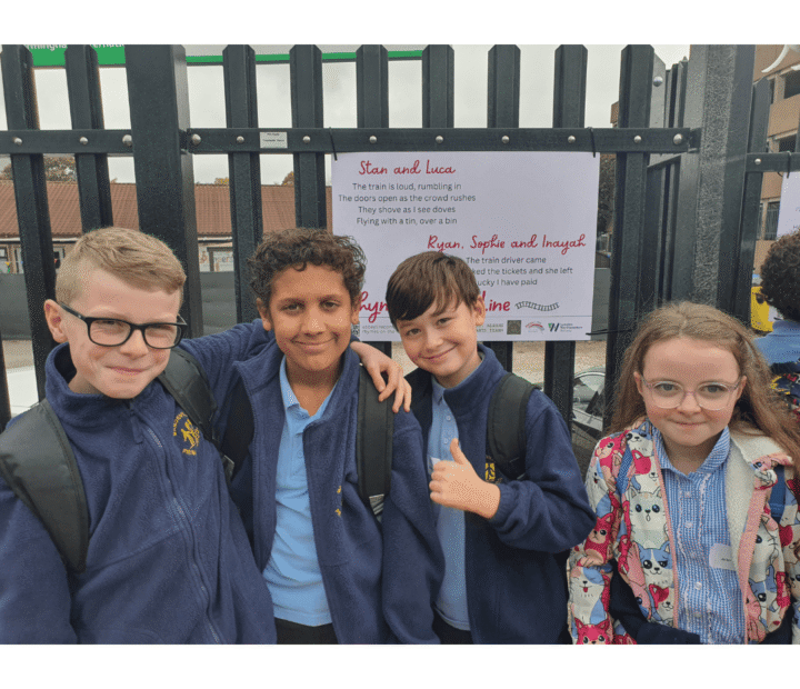 School children looking at creative work on a train platform