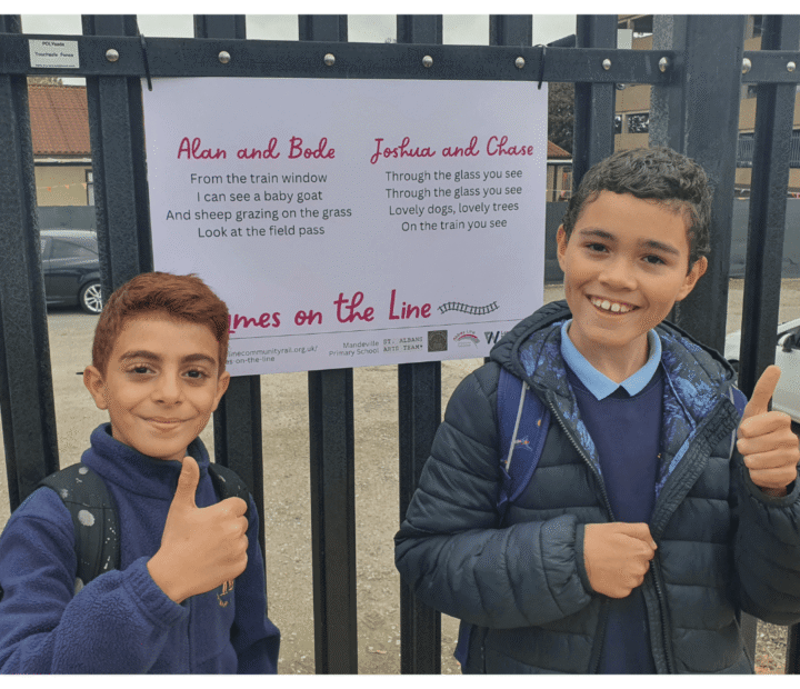 School children looking at creative work on a train platform
