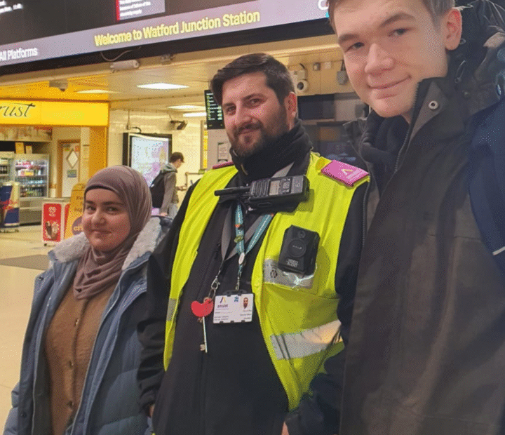 Students at a train station with a member of staff