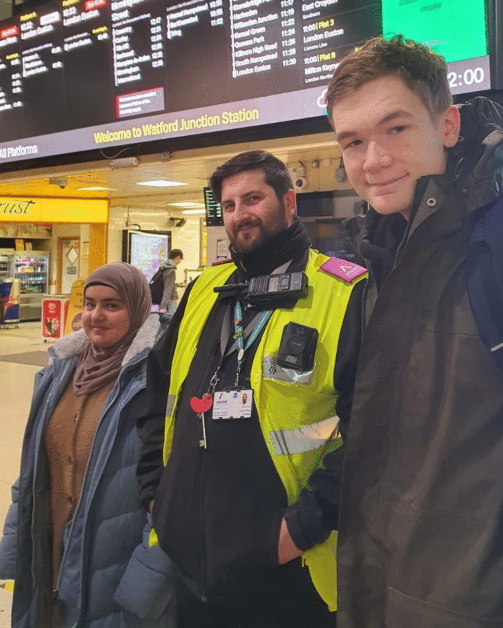 Students at a train station with a member of staff