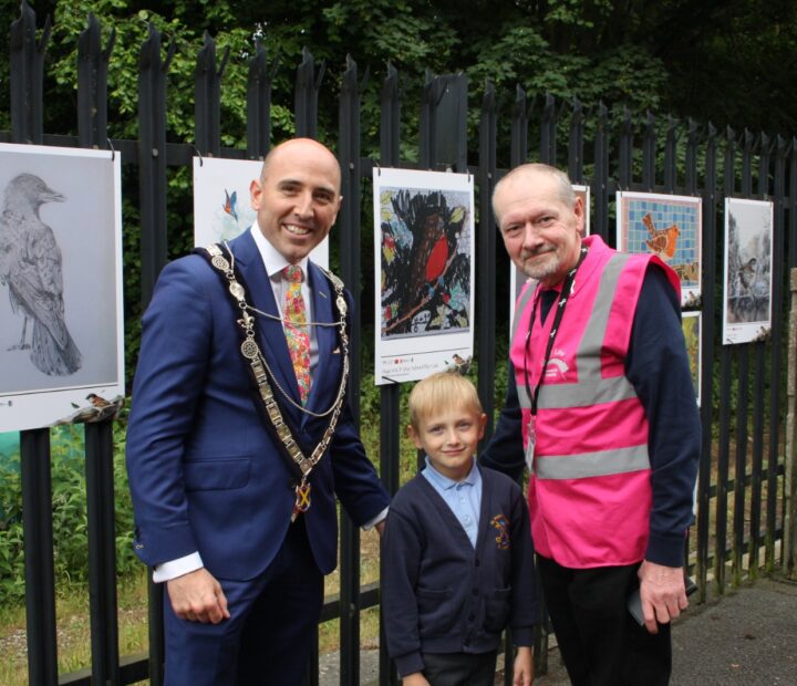 People admiring a community art exhibition at a railway station