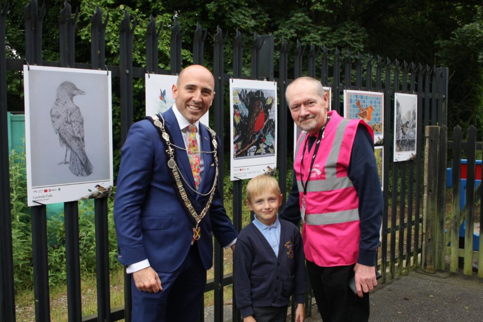 People admiring a community art exhibition at a railway station