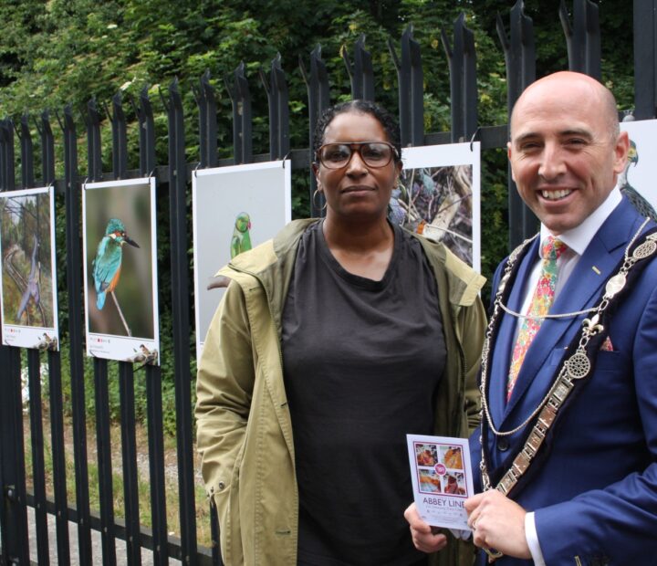 People admiring a community art exhibition at a railway station