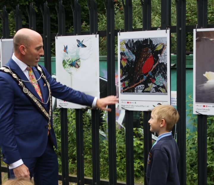 People admiring a community art exhibition at a railway station