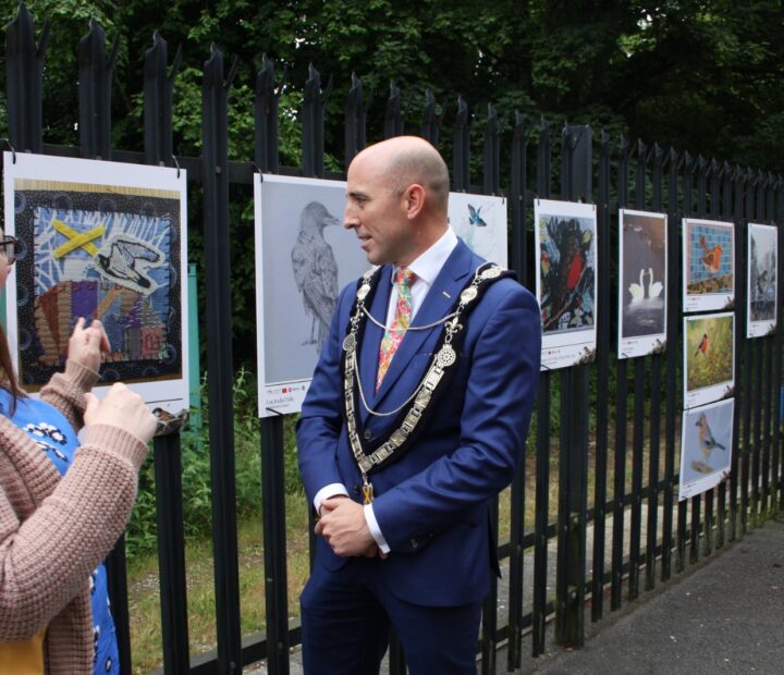 People admiring a community art exhibition at a railway station