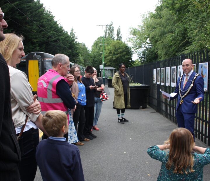 People admiring a community art exhibition at a railway station