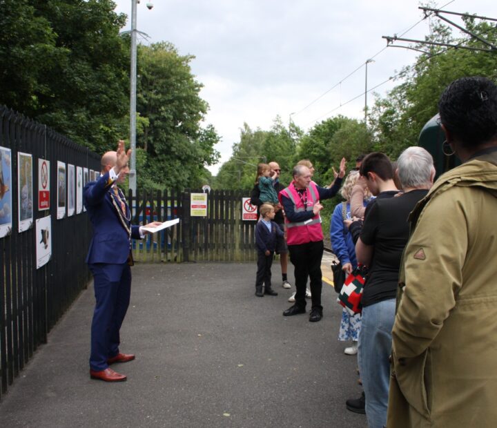 People admiring a community art exhibition at a railway station