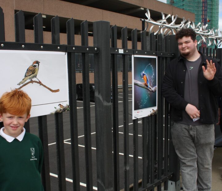 People admiring a community art exhibition at a railway station