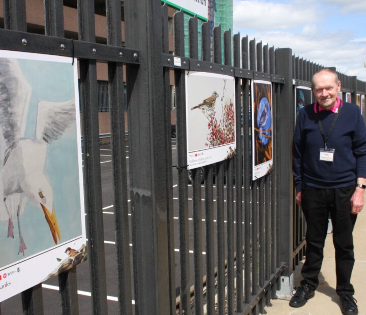 People admiring a community art exhibition at a railway station