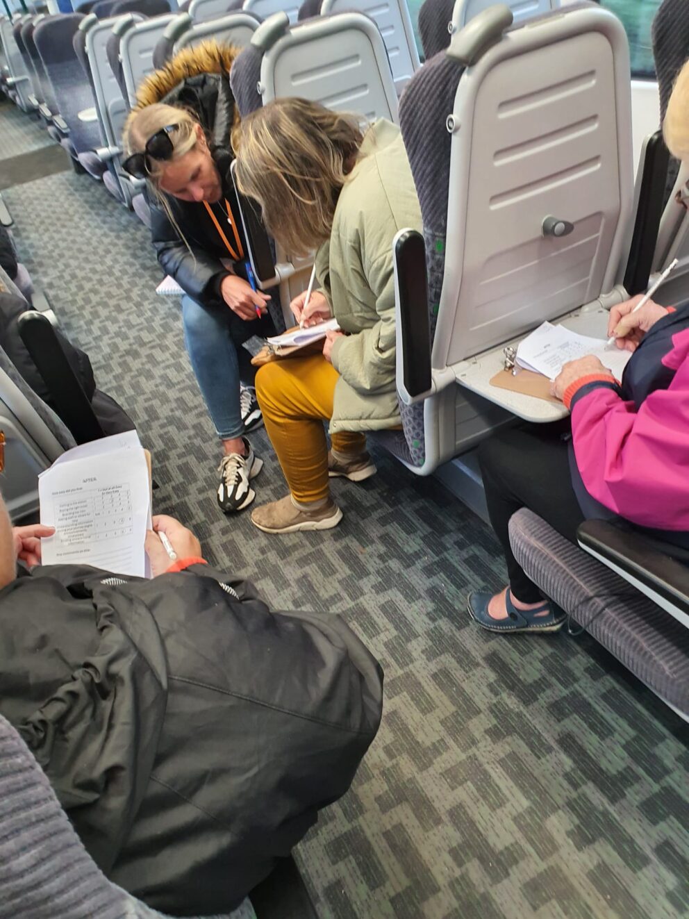 People filling in a survey on a train